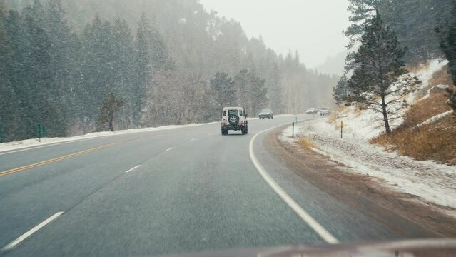 Land Rover Defender D90 Driving On Wintry Road In Snowy Rocky Mountains Alpine Forest Woods Near Nederland Boulder Colorado.