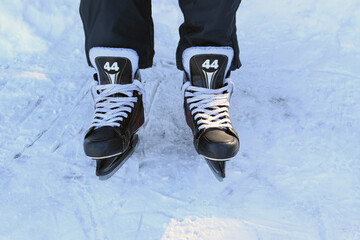  Man in hockey skates outdoors. Only the legs are visible. Skate lacing.