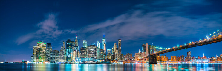 new york city skyline,brooklyn bridge with reflection on water.