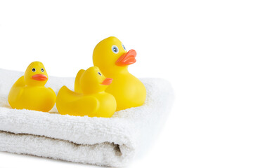 Yellow rubber ducklings on a white terry towel.