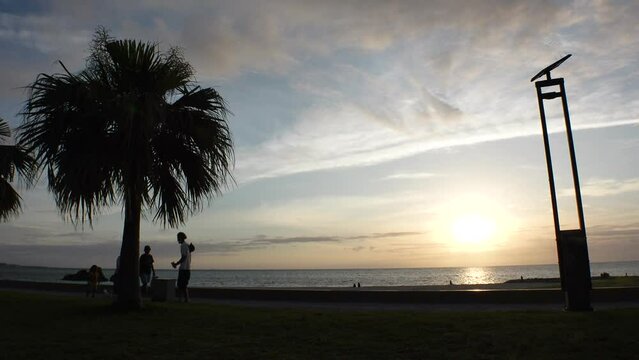 CHTAN-CHO, OKINAWA, JAPAN - AUGUST 2021 : View of Araha beach (Ocean or sea) in dusk. Sunset sky and sea. Romantic summer holiday, vacation and resort concept video.