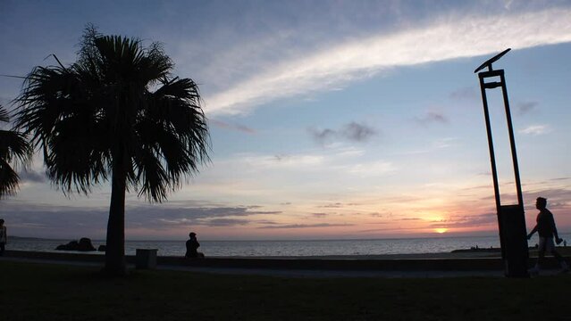 CHTAN-CHO, OKINAWA, JAPAN - AUGUST 2021 : View of Araha beach (Ocean or sea) in dusk. Sunset sky and sea. Romantic summer holiday, vacation and resort concept video.