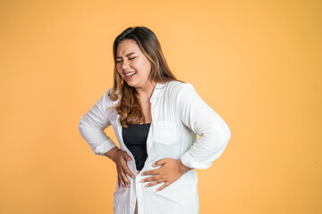 Young asian woman in pain with both hands holding stomach