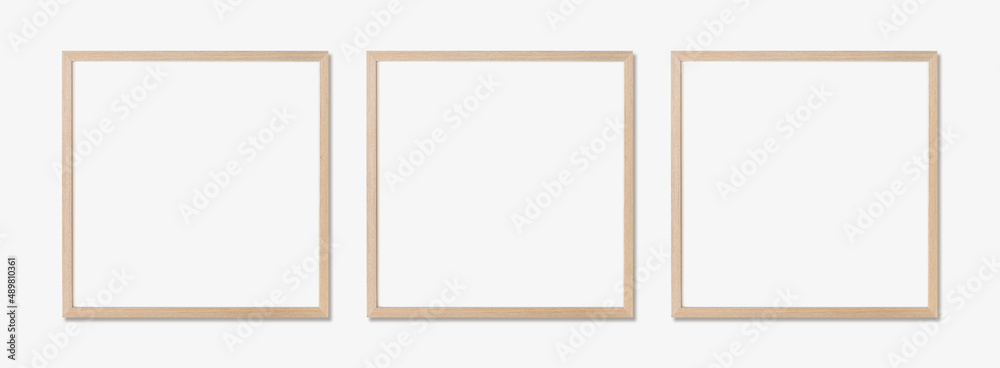 Wall mural picture frame mockup. set of three square oak wooden frames on white wall. template for artwork, pai