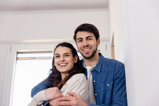 Smiling couple embracing at home renovation work
