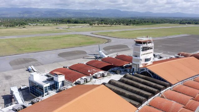 Aerial pan over Cibao airport terminal revealing aircraft runway, Caribbean