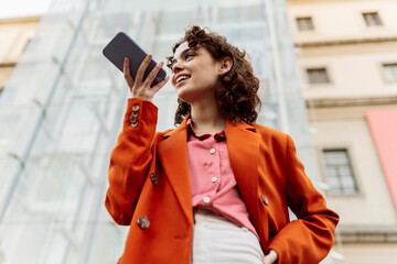 Young woman sending voicemail through smart phone in city