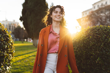 Thoughtful woman walking in park at sunset