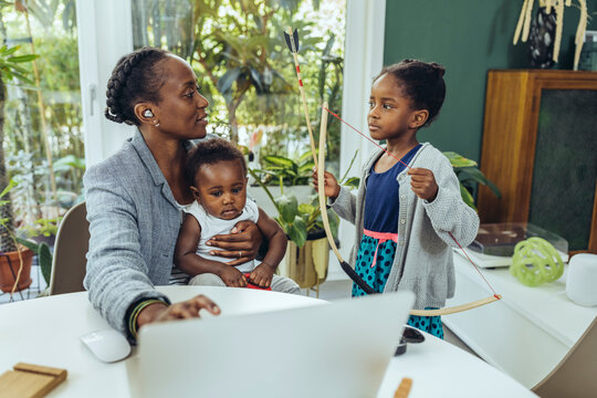 Mother talking to daughter and working at home