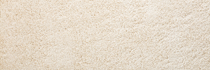 Beige new fluffy home carpet background. Closeup. Wide banner. Empty place for text. Top down view.