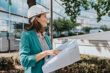Architect wearing smart casuals holding construction plan