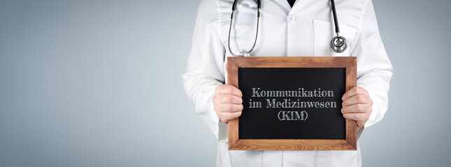 Kommunikation im Medizinwesen (KIM). Arzt zeigt Begriff auf einem Holz Schild.