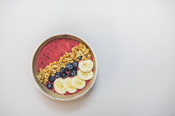 Healthy detox breakfast acai smoothie bowl with fruit topping for healthy lifestyle. Top view on white table