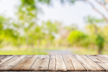 Empty wooden table with garden bokeh for a catering or food background with a country outdoor theme,Template mock up for display of product