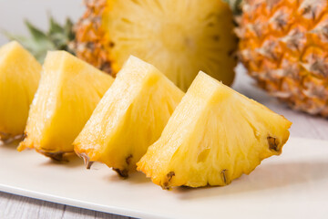 fresh pineapple (Ananas comosus) with slices on wooden table
