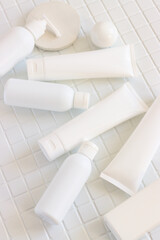 Skincare beauty cosmetic concept. White tube of cream lotion cleanser antioxidant facial oil on white background in a bathroom, vertical