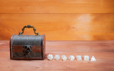 Set of role playing white dices   lie about wooden storage box, concept for playing role-playing game on wooden background with space of text