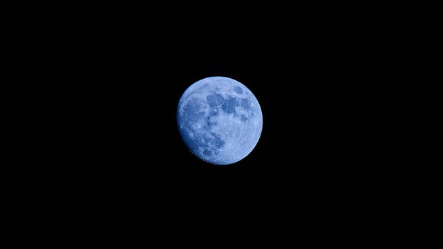 image with blue full moon on black night sky