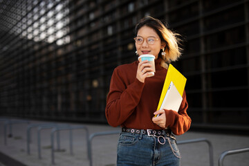 Fototapeta premium Beautiful Chinese woman enjoy in fresh coffee. Young fashion woman holding coffee cup while walking aroung the city.