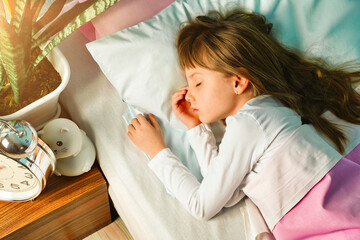 Girl schoolgirl sleeps in pajamas in the bedroom on the bed in the morning close up. The concept of...