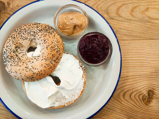 Bagel with cream cheese, peanut butter and blackberry jam. Healthy breakfast