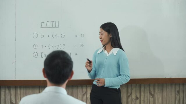Young asian teacher teaching students at classroom.