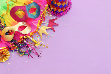 Holidays image of mardi gras masquarade masks over purple background. view from above