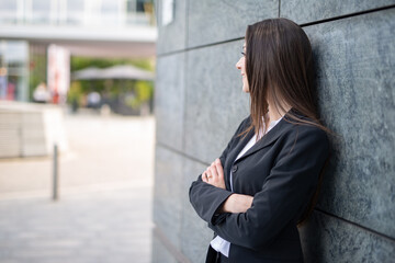 Businesswoman leaning against a wall