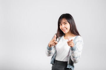 Woman excited smiling makes finger two gun gesture to camera isolated white background, Happy Asian portrait beautiful young female says you are chosen ll kill you or what up man with copy space