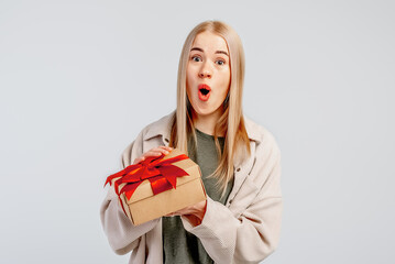 Image of excited young woman opening present gift box. . Pretty girl smiling and posing with gift...