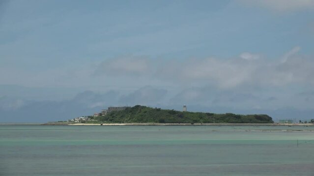 TOMIGUSUKU, OKINAWA, JAPAN - AUGUST 2021 : View of Senaga island and beach (Ocean or sea) in daytime. Clear blue summer sky and clouds. Holiday, vacation and resort concept video.