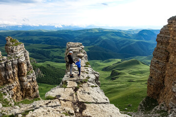 A girl with a child on the background of the mountains and the Bermamyt plateau in Russia. June 2021
