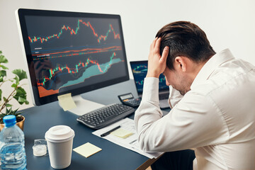 Worried businessman looking at charts stressed by news from stock market. Investor lost money...