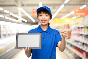 profession, job and people concept - happy smiling delivery woman or saleswoman in blue uniform...
