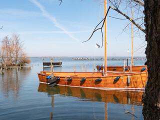 Two wooden sailboats moored on the shore in the afternoon