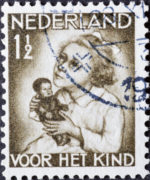 Netherlands - circa 1934: a postage stamp from the Netherlands , showing a Girl with Doll. Text: For the child