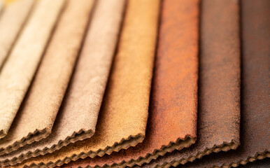 Fabric texture close up. Fabric swatches in different colors are stacked for selection. A variety of shades of upholstery material for furniture and interior. A set of multi-colored rolls of material.