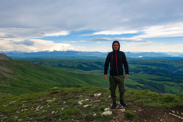 Obraz premium A man on the background of the mountains and the Bermamyt plateau in Russia. June 2021
