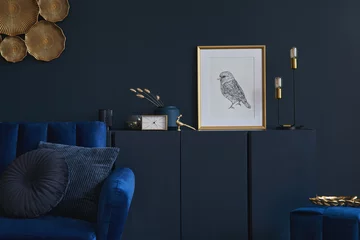 Fotobehang Per kamer Creative composition of glamour living room interior design with mockup poster frame, wooden commode, lamp and elegant personal accessories. Dark blue wall. Home staging. Template. Copy space.  © FollowTheFlow