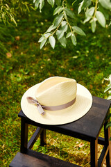 leisure and objects concept - close up of straw hat on stool at summer garden