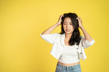 frustrated Asian young woman holding head with headache