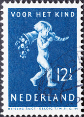Netherlands - circa 1939: a postage stamp from the Netherlands , showing a Child with Horn of plenty. Text: For the child . blue