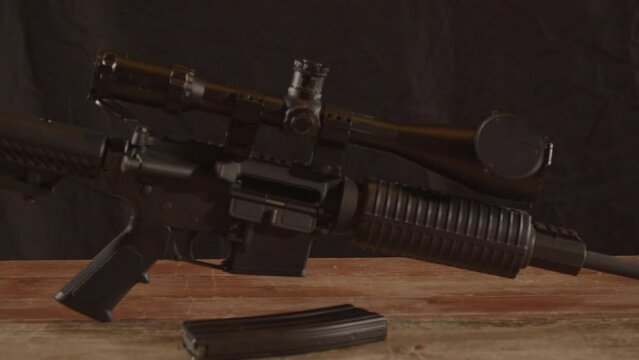 Dolly in of unloaded AR-15 on a wooden surface