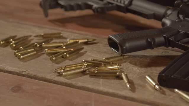 Dolly out over ammunition scattered in front of loaded AR-15