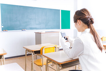 Obraz na płótnie Canvas 教室で携帯電話を使う学生