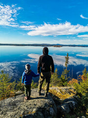 A man with a child on the White Sea coast on a sunny day. Karelia. Russia. SEPTEMBER 2021