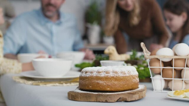 Detail of easter cake on the table and people in the background. Shot with RED helium camera in 8K.