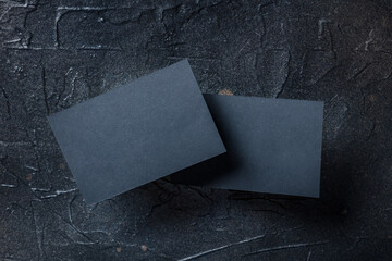 Black business card mockup, front and back, on a dark background, a template for design presentation, thick cardboard visiting cards floating on black