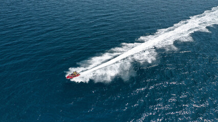 Aerial photo of jet ski with couple cruising in high speed in Caribbean tropical crystal clear deep...
