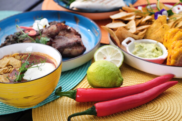 Mexican street food, pepper and lime stands on the table on colored napkins. View from above 
